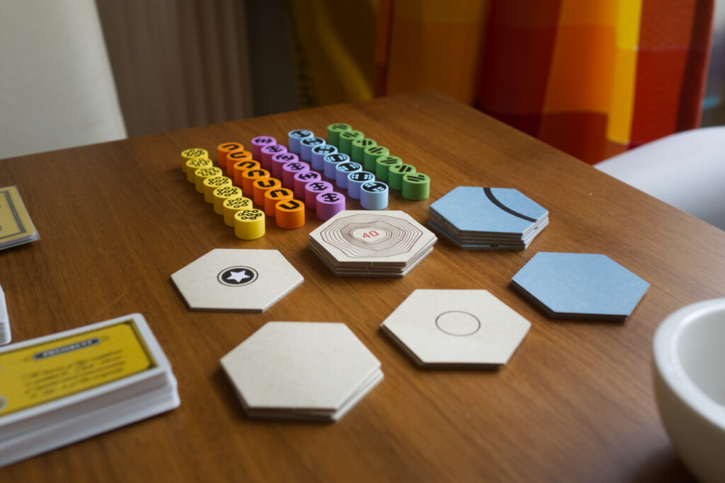 Additional components from board game Railways of the Lost Atlas, single hex tiles, company hubs.