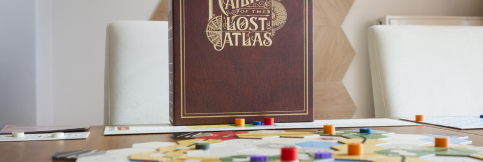 Cover of Railways of the Lost Atlas behind map and game components