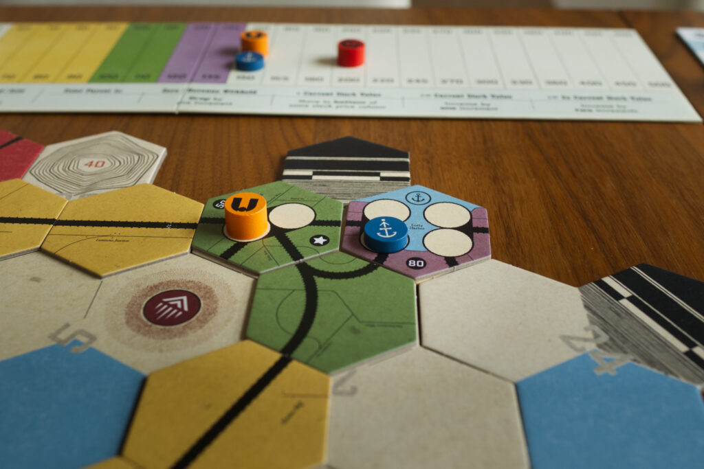 The Northern Port home tile in board game Railways of the Lost Atlas, with company hubs and stock track in background