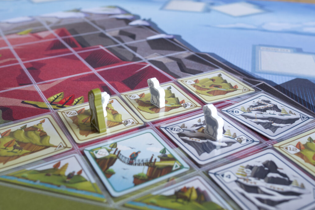 Tranquility the ascent, traveler and sheep meeples on cards and playmat